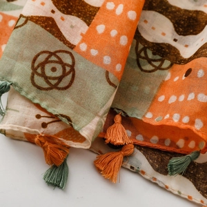 Detailed macro view of soft printed scarf with geometric patterns and colorful fringe