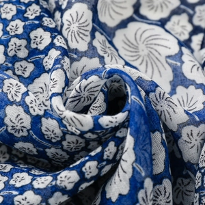 Macro detail of soft blue and white floral scarf fabric with breathable cotton texture