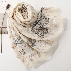 Dettaglio del motivo paisley su sciarpa in cotone crema con bordi a frange morbide