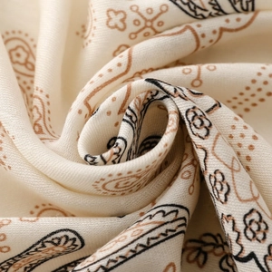 Dettaglio ravvicinato del motivo paisley vintage su morbido tessuto di cotone crema