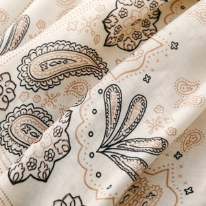 Dettaglio macro della trama paisley vintage su tessuto in raso di cotone beige