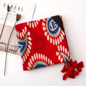 Détail de l'écharpe rouge en coton et lin avec motif cachemire et franges à glands