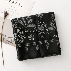 Dettaglio della sciarpa in cotone paisley nero con bordi a frange e tocchi dorati