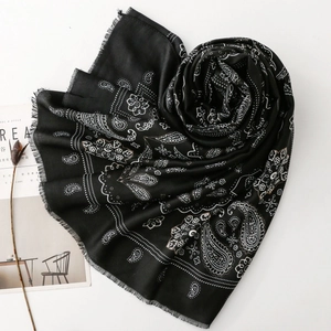 Dettaglio della sciarpa nera con motivo Paisley, bordi sfilacciati e riviste di moda