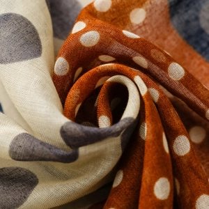 Detailed macro view of polka dot scarf showing linen texture and fringe finish