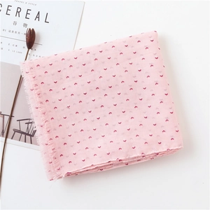 Détail de l'écharpe en coton et lin rose avec motif rouge et bords à franges fins