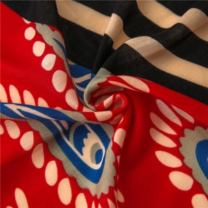 Détail de motifs cachemire et géométriques sur un tissu de châle en coton et lin rouge