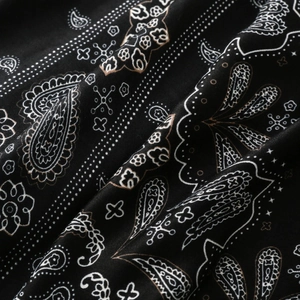 Dettaglio ravvicinato del motivo paisley nero vintage su sciarpa di cotone satinato