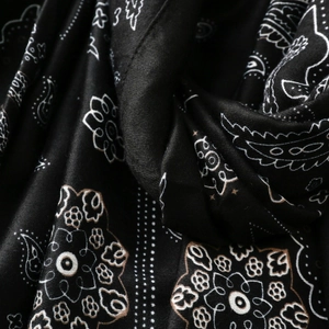 Dettaglio del motivo paisley vintage nero e bianco sulla trama di una sciarpa in seta