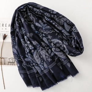 Dettaglio della sciarpa di cotone paisley blu scuro con bordi sfrangiati e consistenza morbida