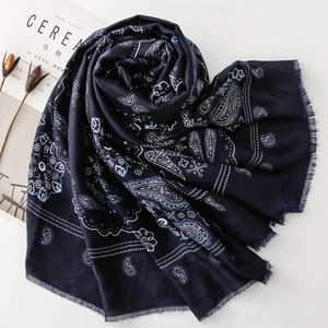 Dettaglio di sciarpa blu scuro con motivo paisley e floreale con bordi sfrangiati