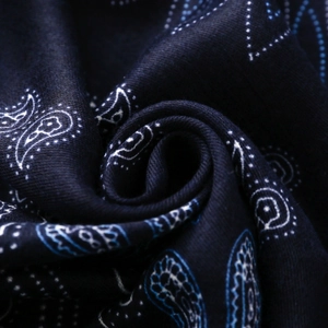 Vista macro di sciarpa in cotone blu navy con motivi paisley e pois bianchi dettagliati