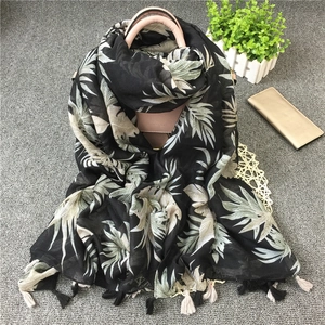 Retro tropical palm leaf print scarf with tassels on a stylish leather handbag