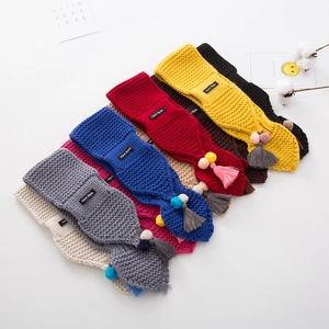 Winter knit scarves for children featuring colorful pom-poms and hand-made tags