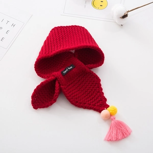Detail of red knit scarf with colorful pom-poms, pink tassels and Hand Made label