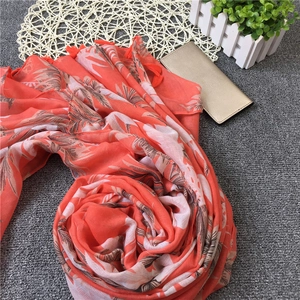 Detail of tropical palm leaf pattern and fringe on orange cotton linen scarf