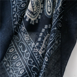 Macro detail of navy blue paisley print scarf showing soft cotton fabric texture