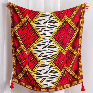 Detail of cotton linen scarf with zebra stripes, geometric borders and red tassels