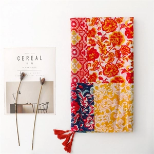 Ethnic patchwork floral scarf with red peonies, tassels, and artistic magazine background