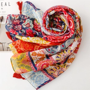 Detail of vintage bohemian floral scarf with red corner tassels and paisley patterns
