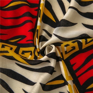 Detail of soft cotton linen scarf with zebra print and geometric pattern in red and yellow