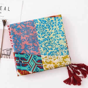 Detail of bohemian printed shawl with colorful totem patterns and red tassel accents
