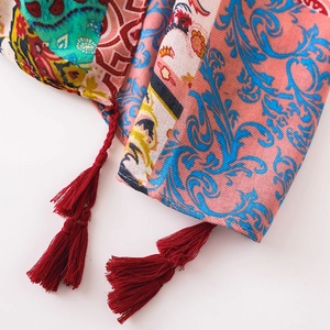 Detailed view of colorful ethnic pattern shawl with red woven tassel fringe edges