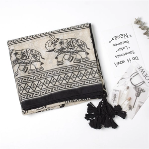 Detail of ethnic elephant print scarf featuring black tassels and soft linen texture