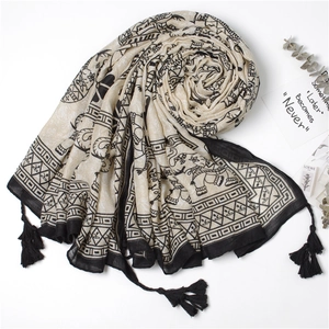 Detail of bohemian cotton linen scarf featuring black elephant prints and fringe edges