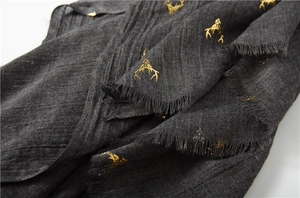 Macro shot of dark grey cotton linen scarf with golden deer foil print and fringe details