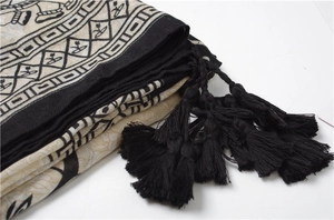 Detail of ethnic elephant print scarf featuring black handmade fringe and cotton texture