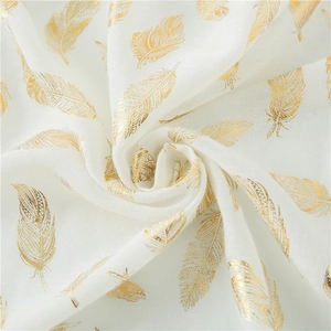 Detail of white cotton shawl showing delicate gold feather foil print texture