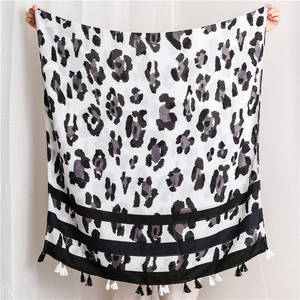 Detail of leopard print cotton shawl with striped border and two-tone fringe tassels
