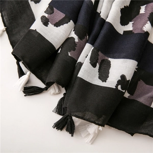Close-up of leopard pattern scarf with herringbone weave and fringe tassel details