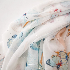 Close-up of butterfly print scarf with silver glitter threads and soft sheer fabric