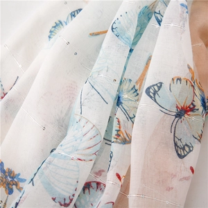 Close-up of butterfly print fabric with silver metallic threads and glitter details