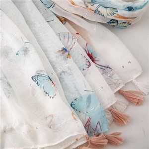 Detail of lightweight linen scarf with colorful butterfly prints and silver sequins