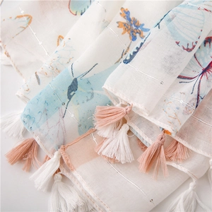 Detail of linen shawl with butterfly print, metallic silver threads and pink tassels
