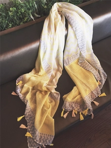 Detail of yellow and grey wavy stripe pattern scarf with soft fringe tassels on edges