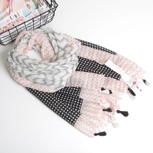Detail of checkered and wavy pattern scarf with black and white decorative tassels