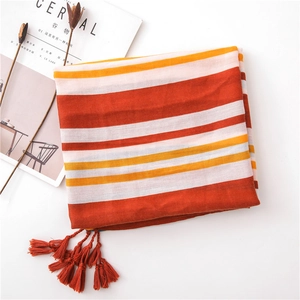 Detailed texture of orange and white striped cotton scarf with hand-tied fringe trim