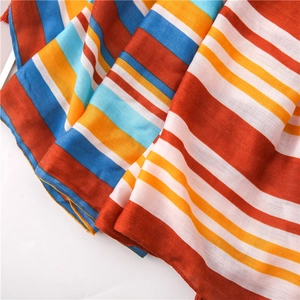 Detailed view of colorful striped fabric texture and delicate fringe tassels of the scarf