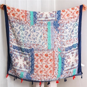 Close-up of bohemian scarf with floral paisley prints and vibrant colorful tassels