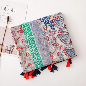 Detail of bohemian scarf featuring intricate paisley floral patterns and colorful tassels