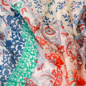 Detailed macro shot of vintage floral pattern fabric with colorful tassels and soft texture