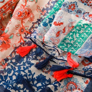 Close-up of ethnic paisley floral patterns and colorful tassels on cotton linen scarf
