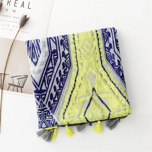 Detail of bohemian scarf showing geometric yellow patterns and colorful tassel edges