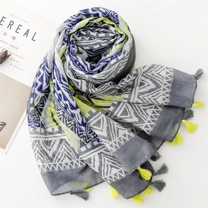 Detail of geometric scarf with grey and yellow patterns and cotton tassel fringe