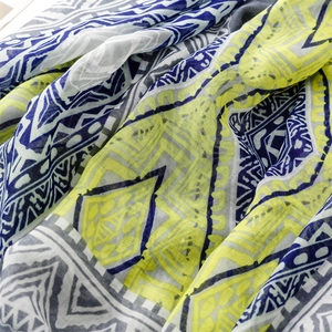 Macro detail of bohemian geometric scarf fabric in neon yellow and navy blue hues