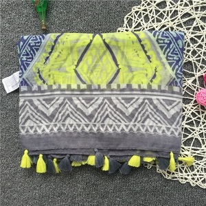 Detail of neon yellow and navy geometric print scarf with fringed edges and brand tag